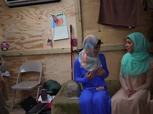 Zwei arabische Babes küssen sich, während Soldaten zuschauen. Zwei