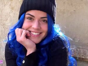 Schoonheid met blauw haar trekt zich af op een openbare plek met een