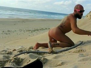 Kille knullar sig själv på stranden med en trädildo