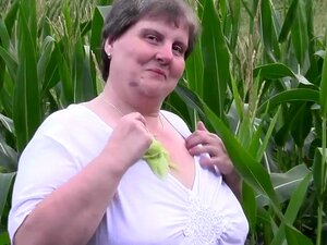 Große muskulöse Mama macht das in einem Maisfeld,